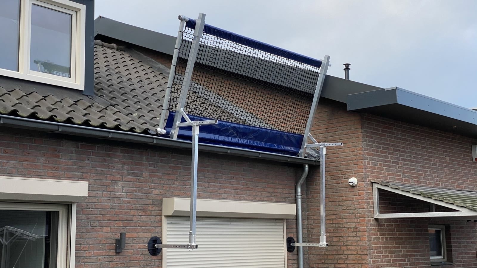 Dakrandbeveiliging met valnet langs de goot van een schuin dak