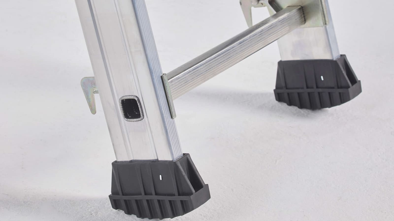 Voeten en stabiliteitsbalk van een ladder op de vloer