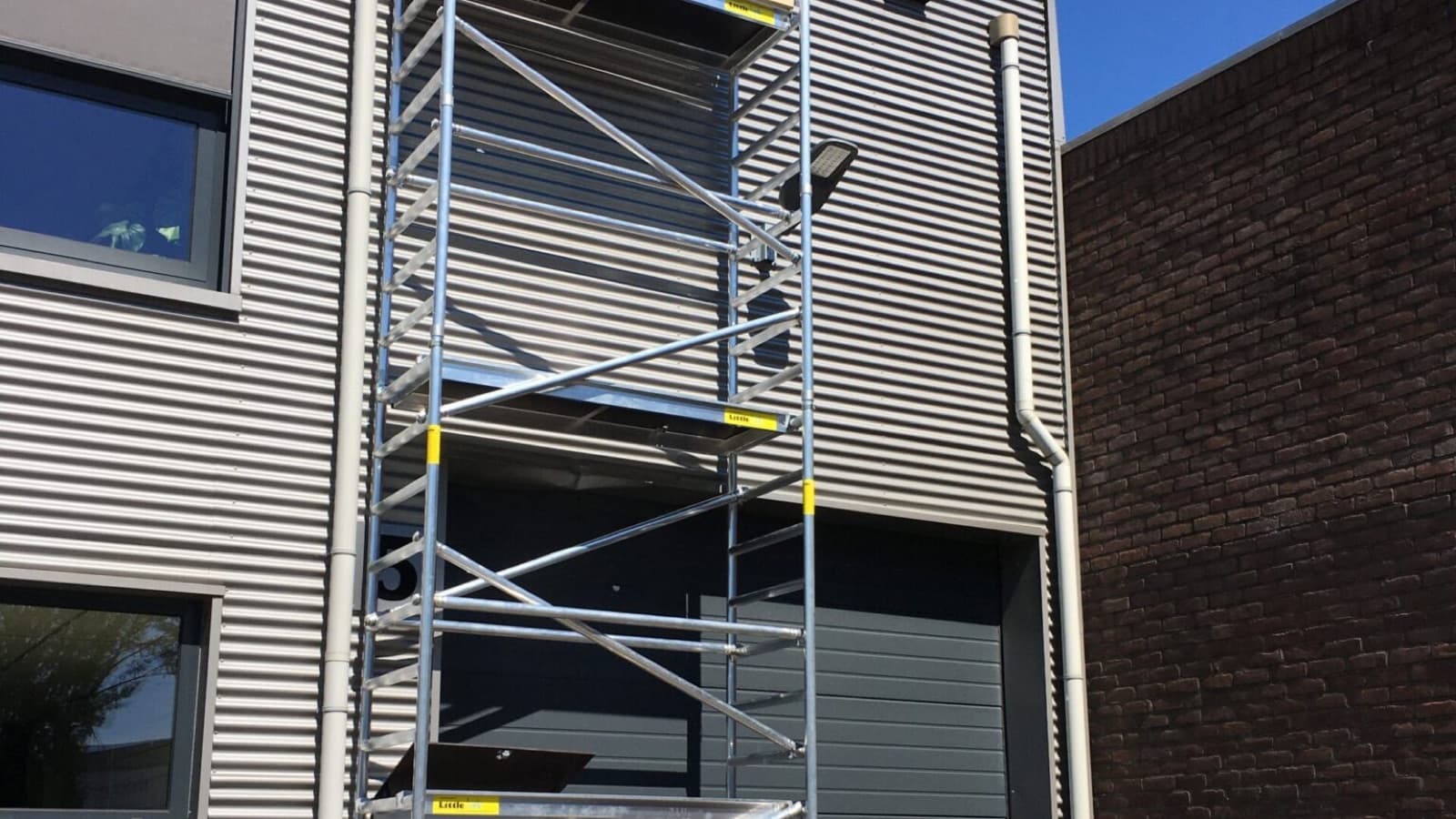 Rolsteiger met stabilisatoren tegen een bedrijfspand