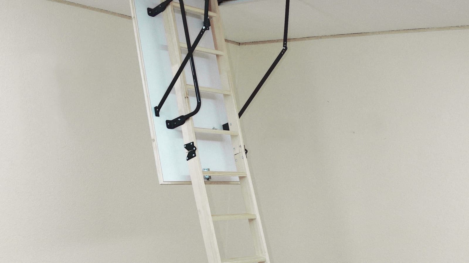Houten vlizotrap uitgeklapt uit een plafondluik