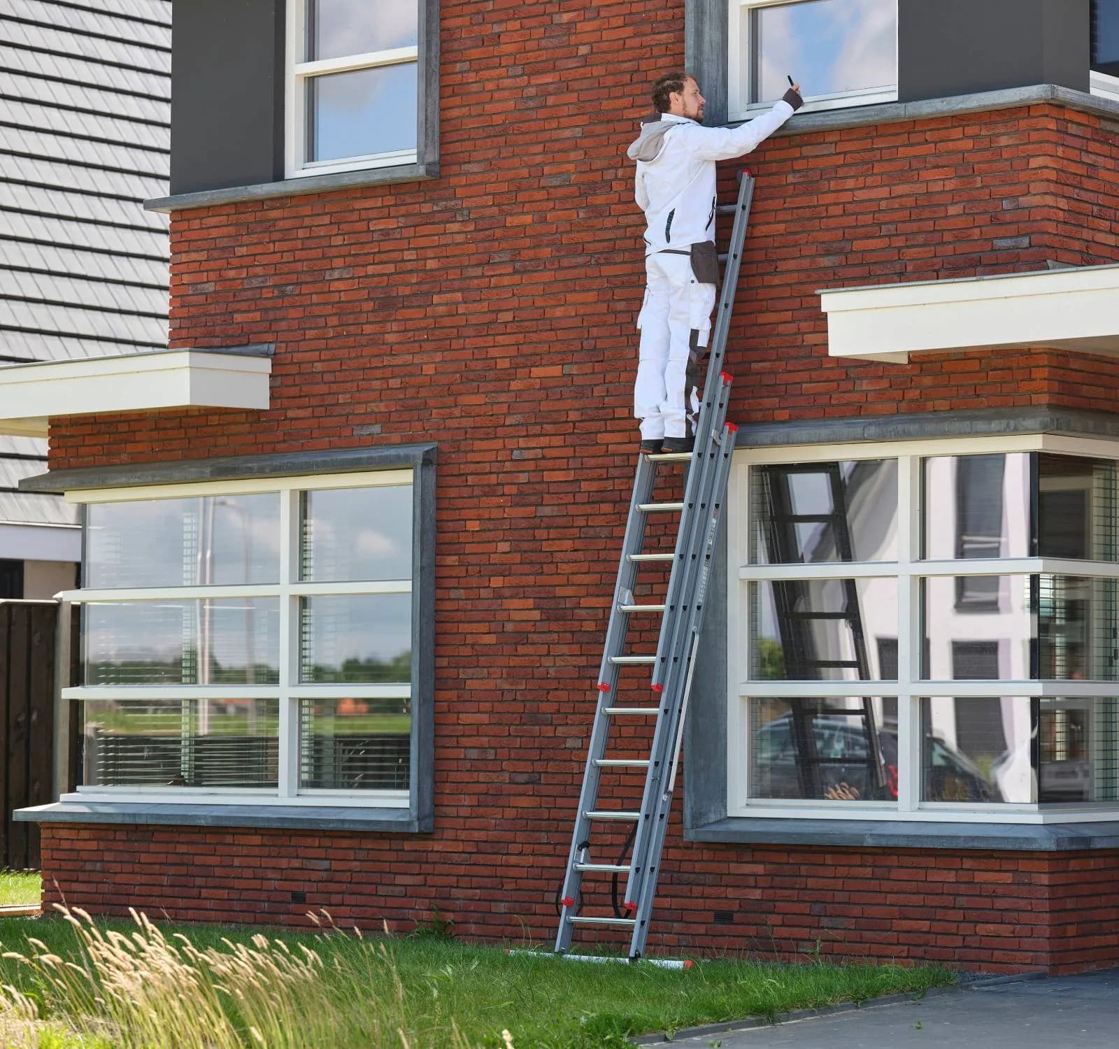 Schilder op een professionele reformladder tegen een gevel